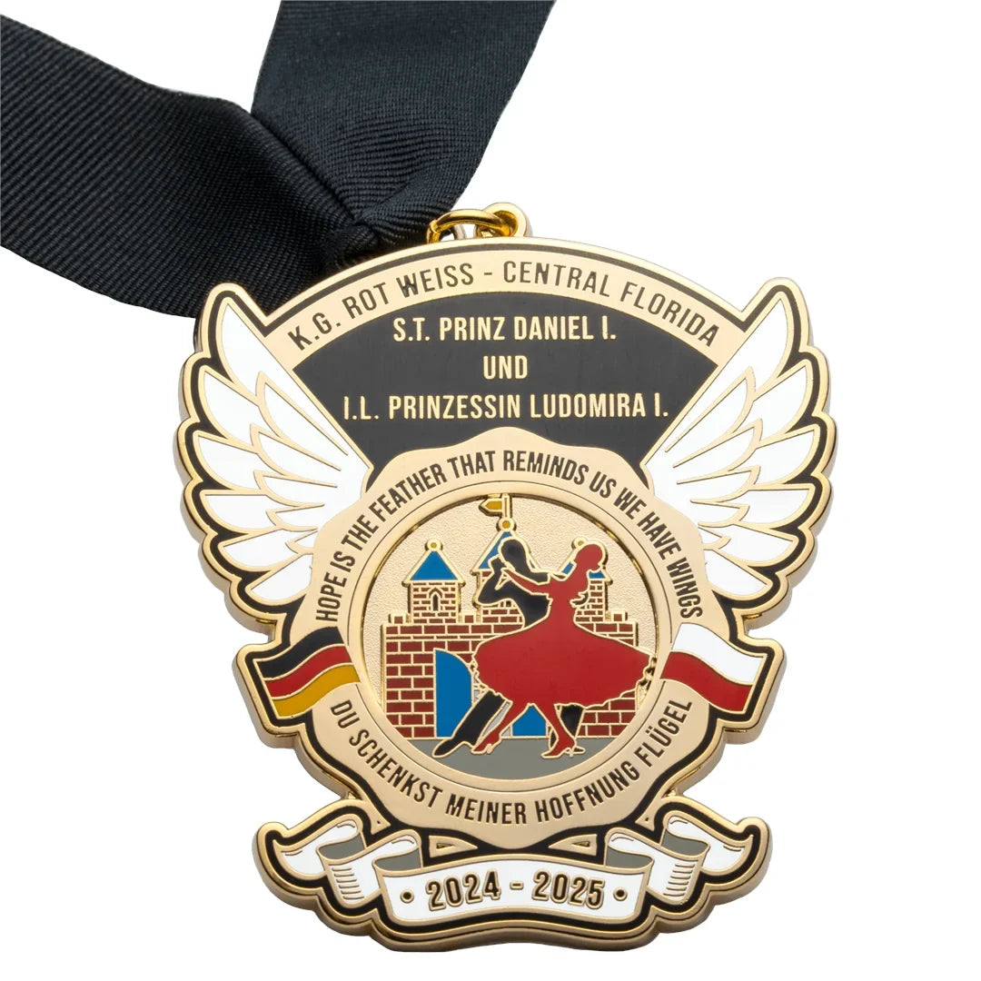 Gold plated medal with sculpted wings, dancing figures and a castle, on a black neck ribbon