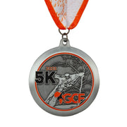 Antique silver custom 5K medal with a sculpted figure in relief and orange enamel accents